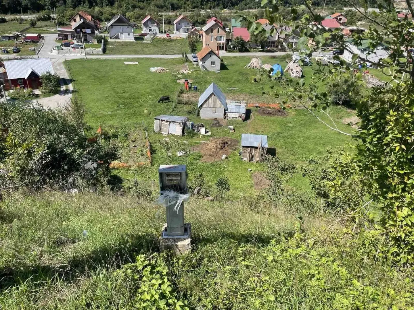 Pogled na plac sa pomoćnim objektima i okolnim kućama.