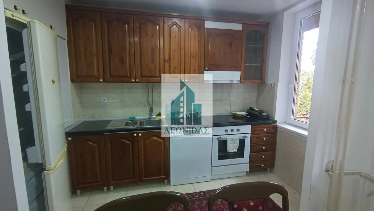 Kitchen with wooden cabinetry, sink, and built-in stove.