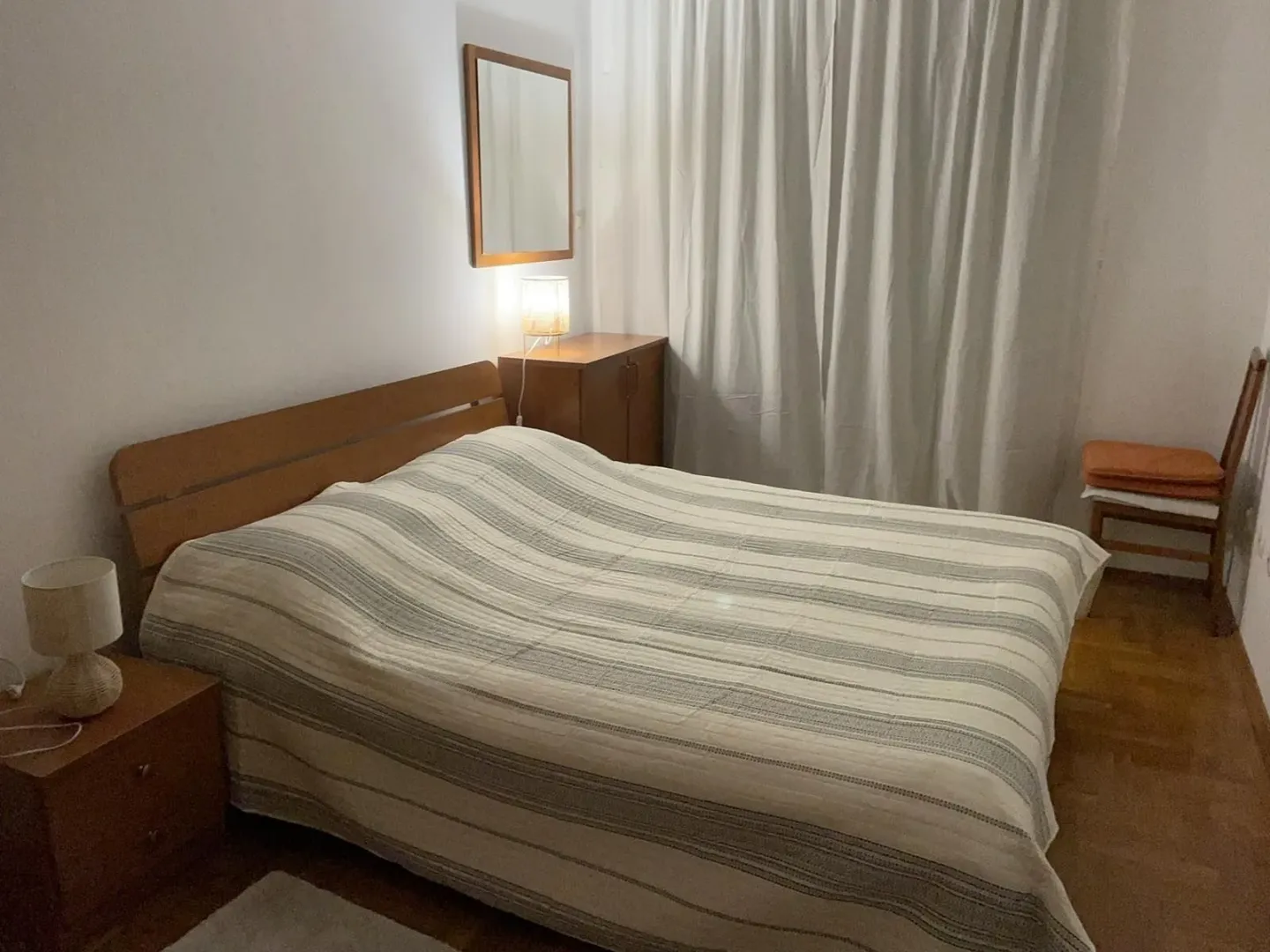 Jednostavna spavaća soba sa bračnim krevetom.