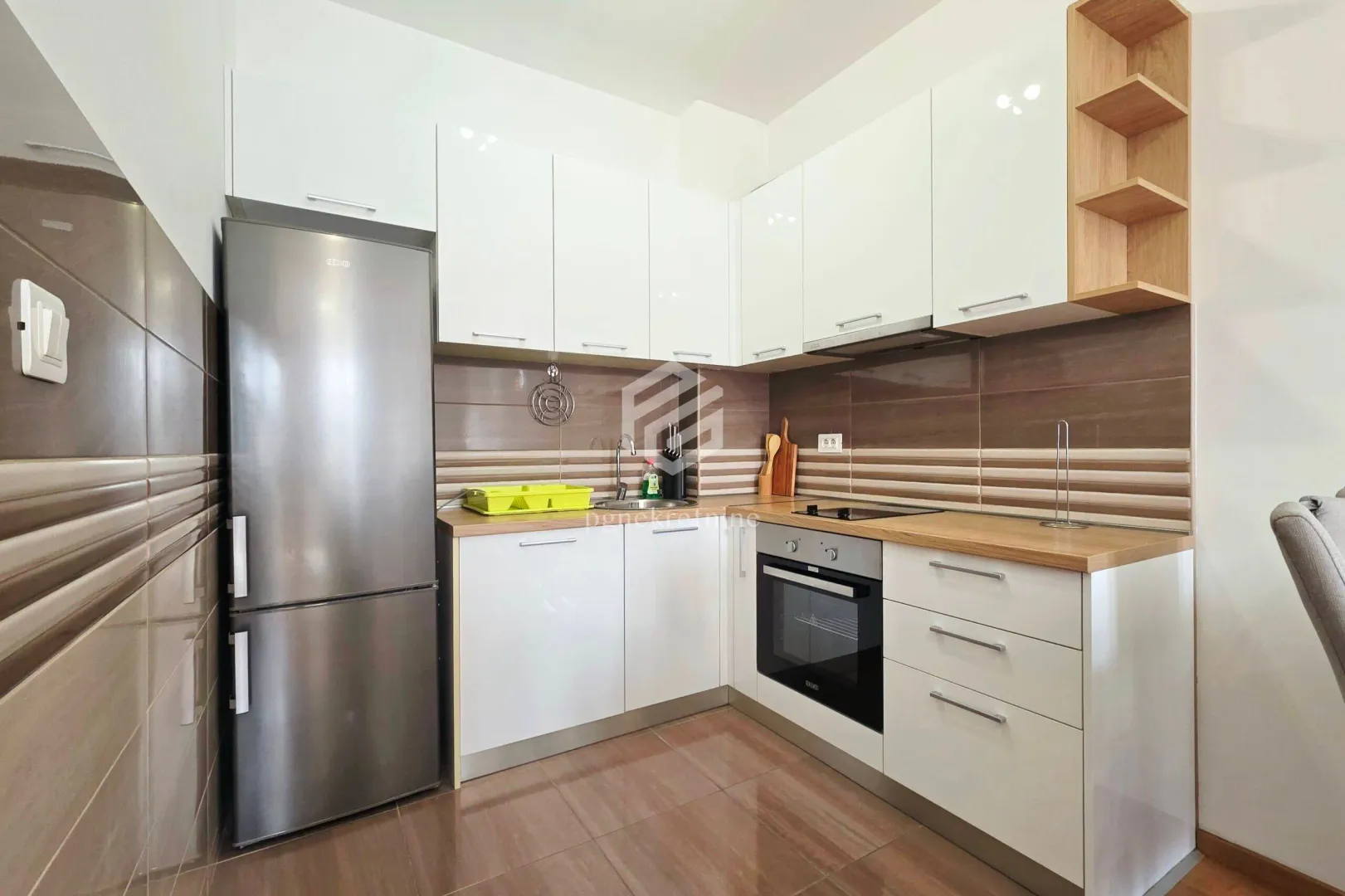 Kitchen with white cabinetry, wooden countertop, and built-in appliances.