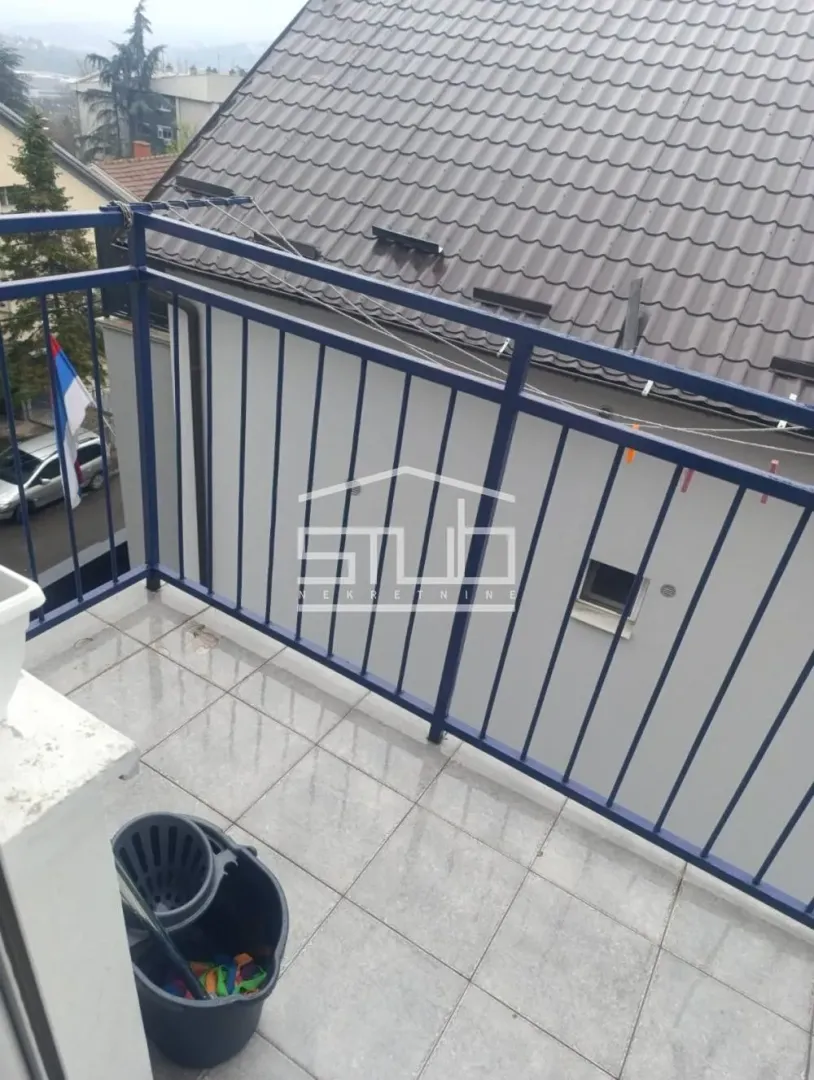 Balcony with tiled flooring and a blue metal railing.