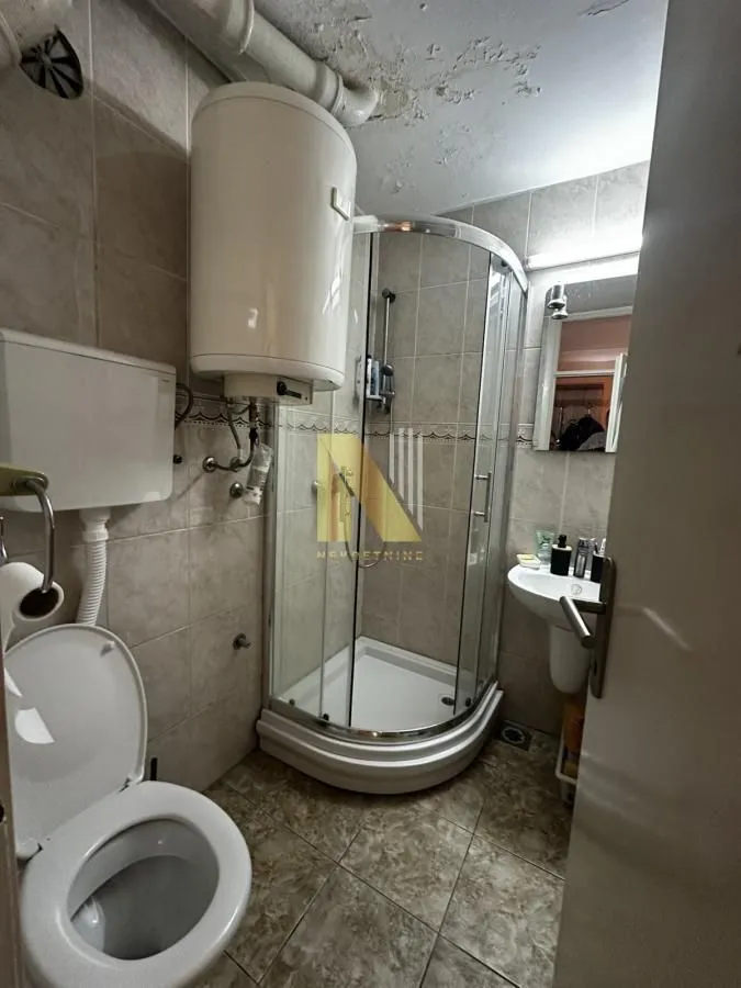 Manje kupatilo sa tuš kabinom, wc šoljom, bojlerom i umivaonikom.