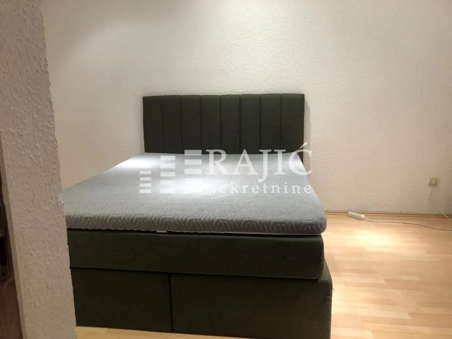 Nameštena spavaća soba sa bračnim krevetom.