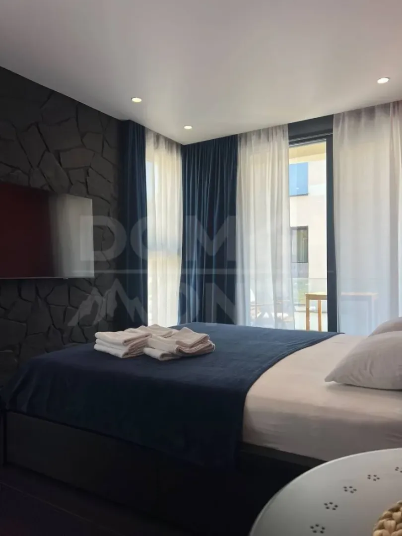 Modern bedroom with a double bed, TV, and access to the terrace.