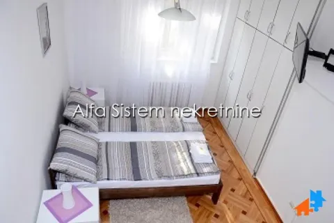 Bedroom with two single beds, a large wardrobe, and wooden flooring. - image 6