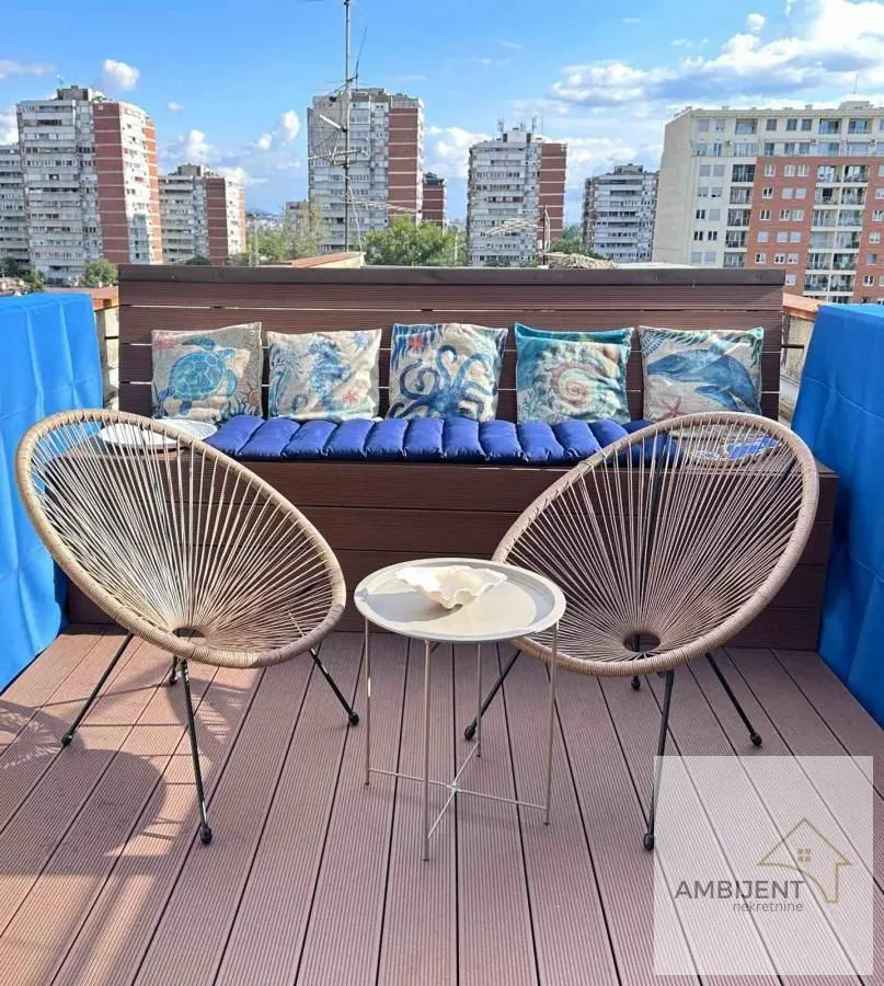 Furnished rooftop terrace with seating furniture and a city view.
