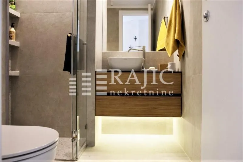 Modern bathroom with washbasin and walk-in shower.