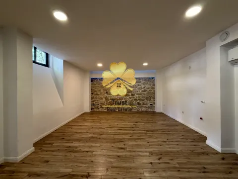 Empty room with wooden flooring and a stone accent wall. - image 12