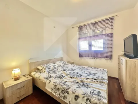 Bedroom with a double bed, nightstand, and a window with purple curtains. - image 6