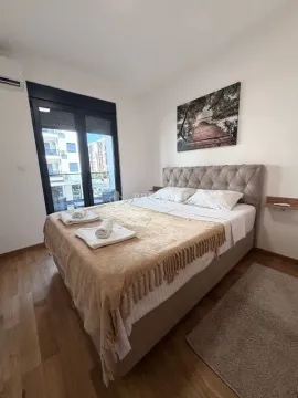 Furnished bedroom with a large double bed and balcony doors. - image 9