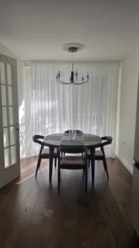 Dining area with a wooden table and chairs overlooking the courtyard. - image 13
