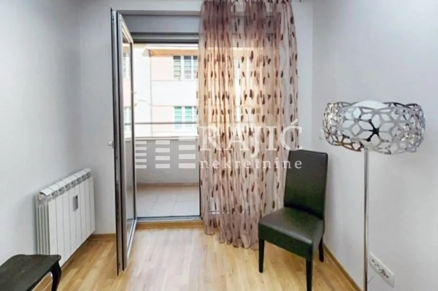 Smaller room with wooden flooring, a chair, and access to the terrace.