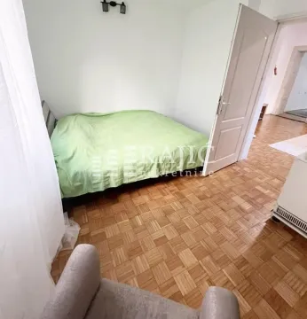 Furnished bedroom with a double bed and parquet flooring. - image 7