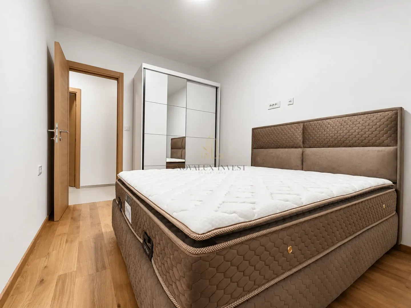 Furnished bedroom with a double bed and a wardrobe.