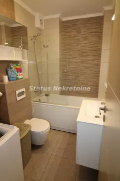 Modern bathroom with bathtub, shower screen, washbasin, and toilet. - image 14