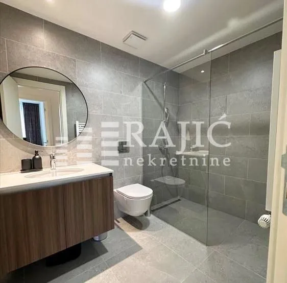 Modern bathroom equipped with a walk-in shower and vanity unit.