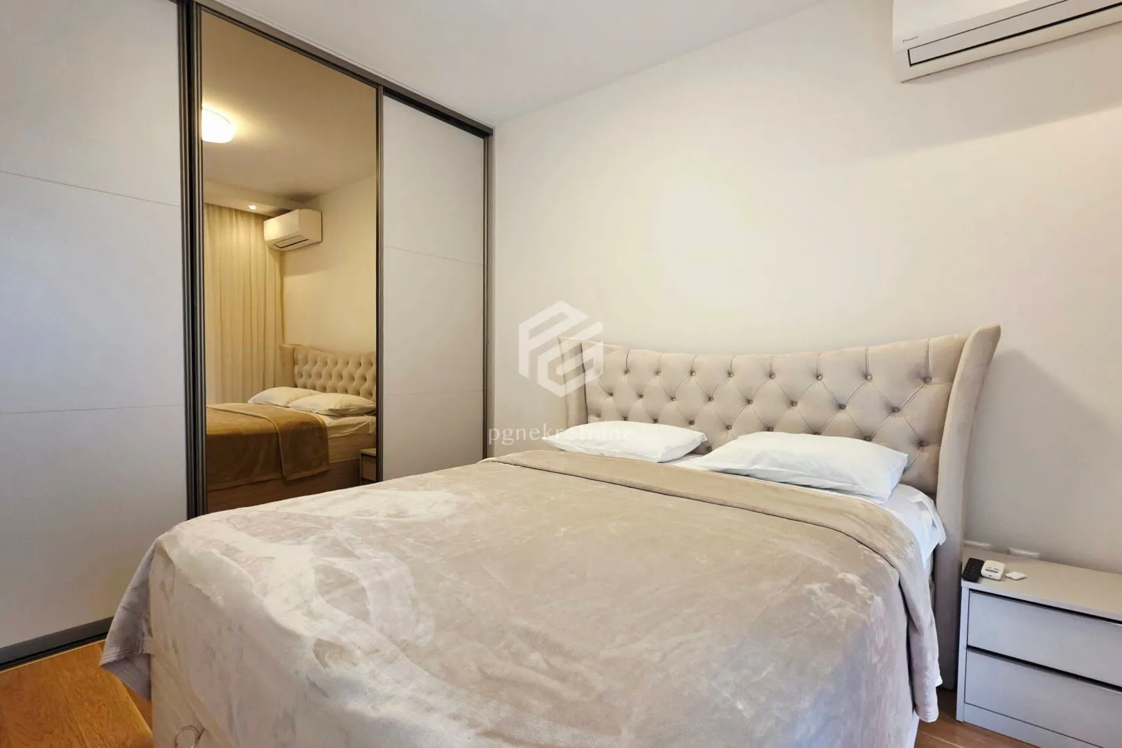 Bedroom with a double bed and a fitted wardrobe with a mirror.