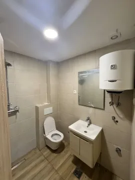 Manje kupatilo obloženo keramičkim pločicama sa tuš kabinom, umivaonikom i wc šoljom. - image 3