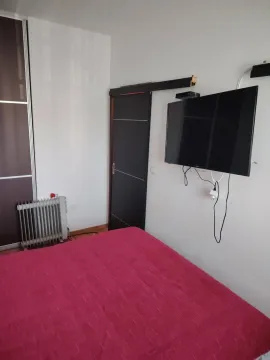 Spavaća soba sa krevetom, plakarom i televizorom na zidu. - image 6
