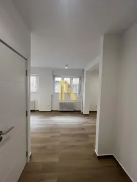 View from the hallway into a spacious bright living room with parquet flooring. - image 10