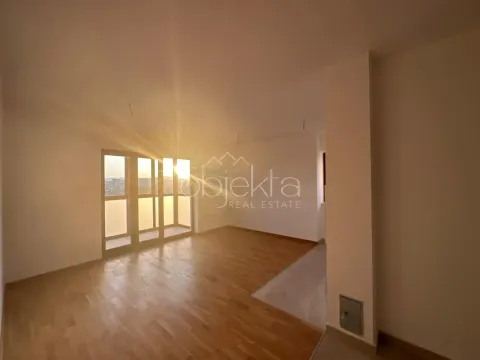 Prazna soba sa parketom i velikim prozorima kroz koje dopire sunčeva svetlost. - image 8
