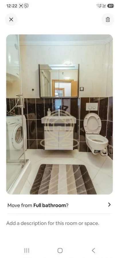 Bathroom equipped with a washbasin, toilet, shower enclosure, and washing machine.