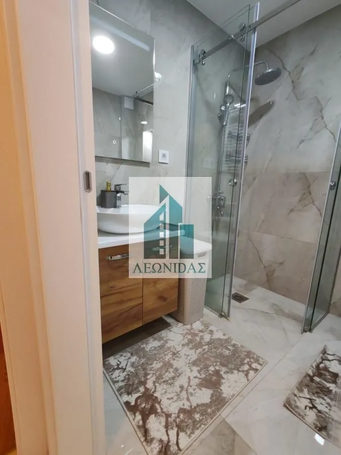 Modernly equipped bathroom with a walk-in shower and a washbasin.