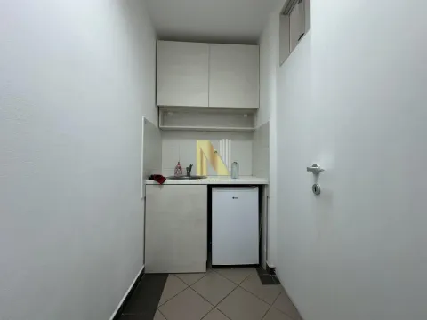 Small kitchen with a sink, cabinetry, and a refrigerator. - image 5