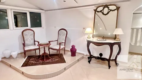 Living room with seating furniture and a large wall mirror. - image 6