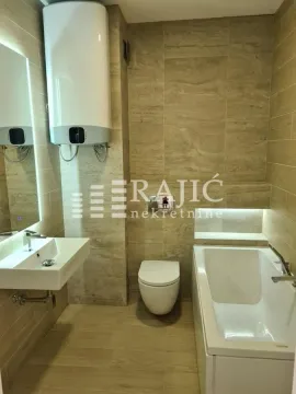 Modernly equipped bathroom with a bathtub and built-in fixtures. - image 3