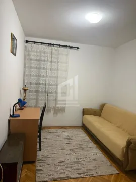 Small room with a sofa, a desk, and a window with curtains. - image 4