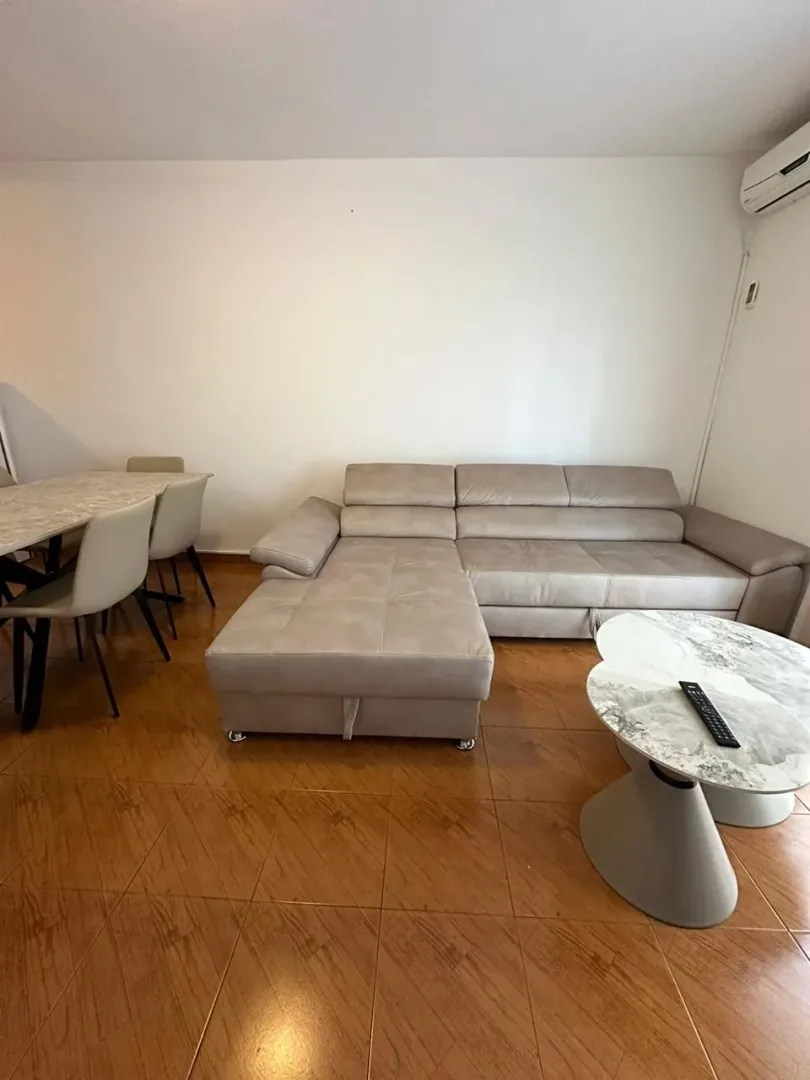Dnevna soba sa garniturom, trpezarijskim stolom i stočićem.
