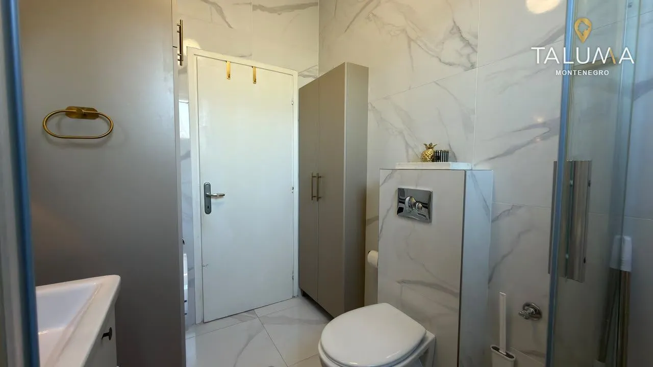 Moderne kupatilo sa tuš kabinom, WC šoljom i umivaonikom.