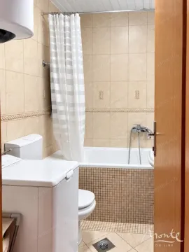 Kupatilo obloženo keramičkim pločicama sa kadom, toaletom i veš mašinom. - image 10