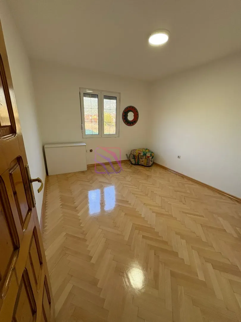 Empty room with parquet flooring and a window.