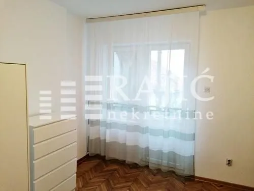 Bright bedroom with a white dresser and a window with curtains.