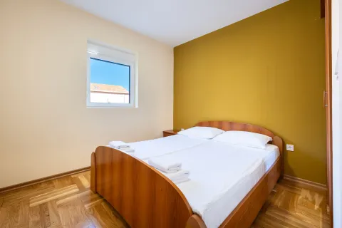 Bedroom with a double bed, wooden floor and a window. - image 5