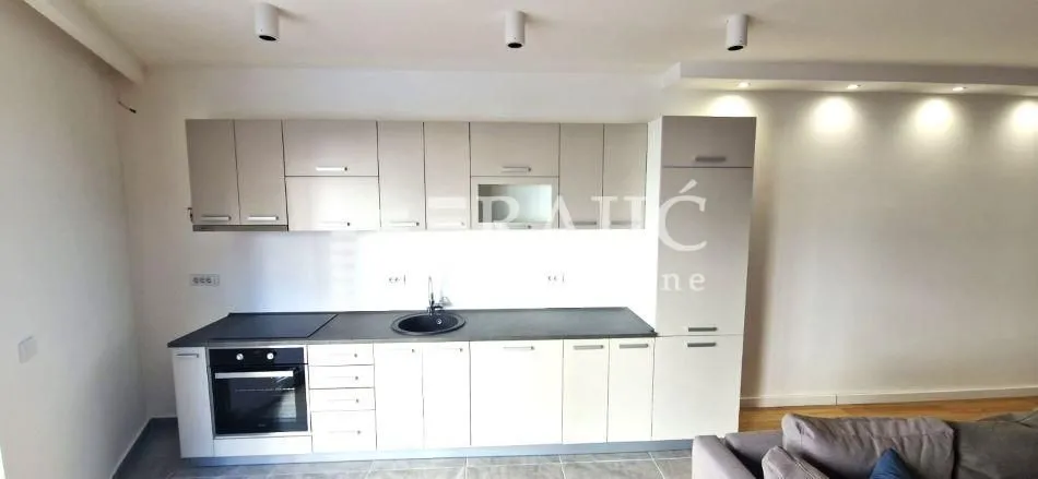 Modern kitchen with white cabinetry and built-in appliances.