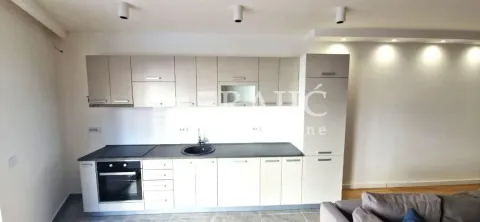 Modern kitchen with white cabinetry and built-in appliances. - image 7