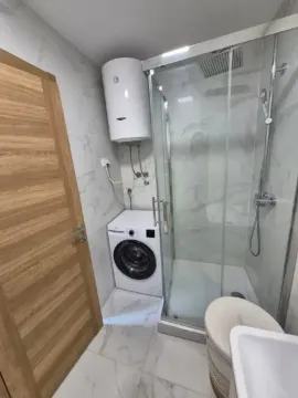 Kupatilo opremljeno tuš kabinom, veš mašinom i bojlerom. - image 7