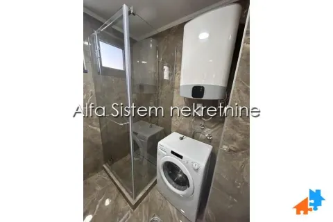 Bathroom with a shower cabin, water heater, and washing machine. - image 12