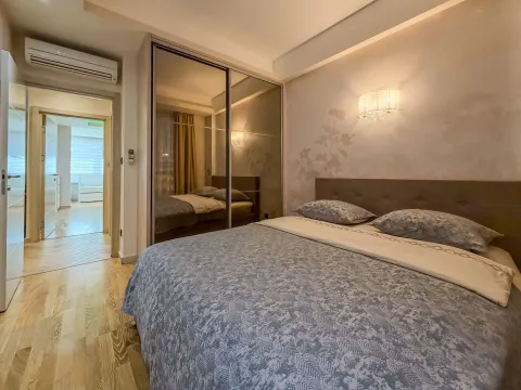 Spavaća soba sa bračnim krevetom, velikim garderoberom sa ogledalima i izlazom u hodnik. - image 11