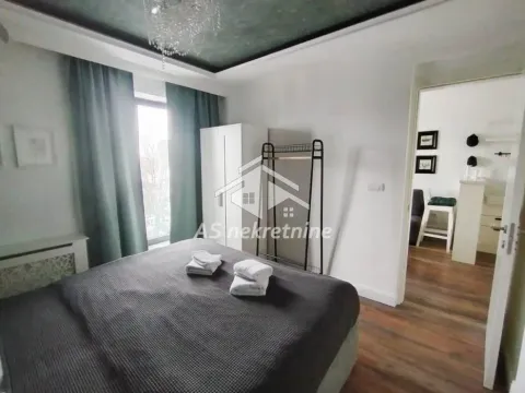 Bedroom with a double bed, wardrobe, and a window with curtains. - image 15