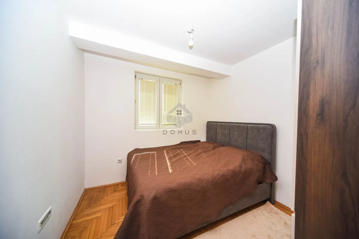 Small bedroom with a double bed and parquet flooring.