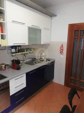 Kuhinja sa belim i tamnoplavim elementima i drvenim vratima. - image 10
