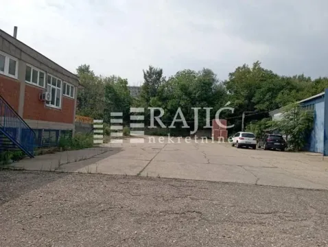 Paved courtyard with buildings and parked cars. - image 10