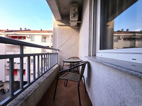 Furnished balcony with seating set and a view of neighboring buildings. - image 4