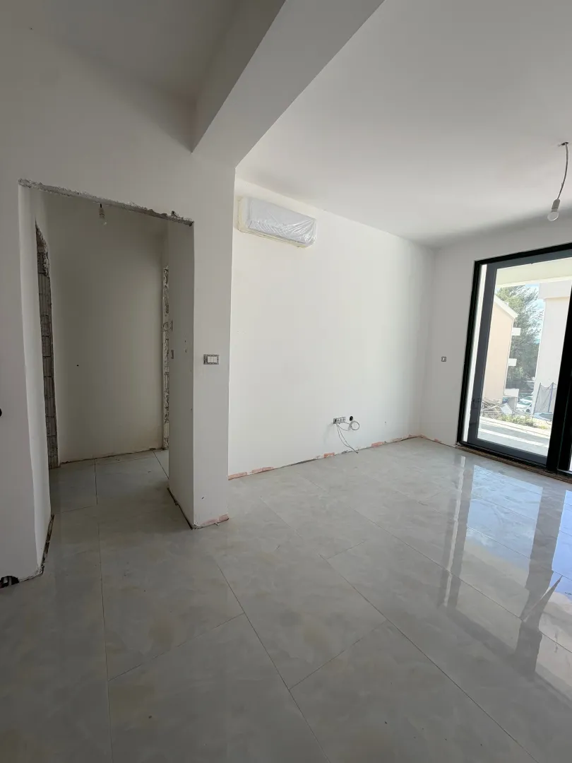 Empty room in a new building with ceramic tiles and an installed air conditioner.