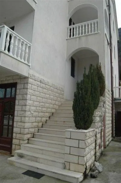 Vanjske stepenice koje vode do ulaza u kuću sa kamenom fasadom.