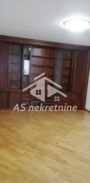 Living room with a large wooden cabinet and parquet flooring. - image 9